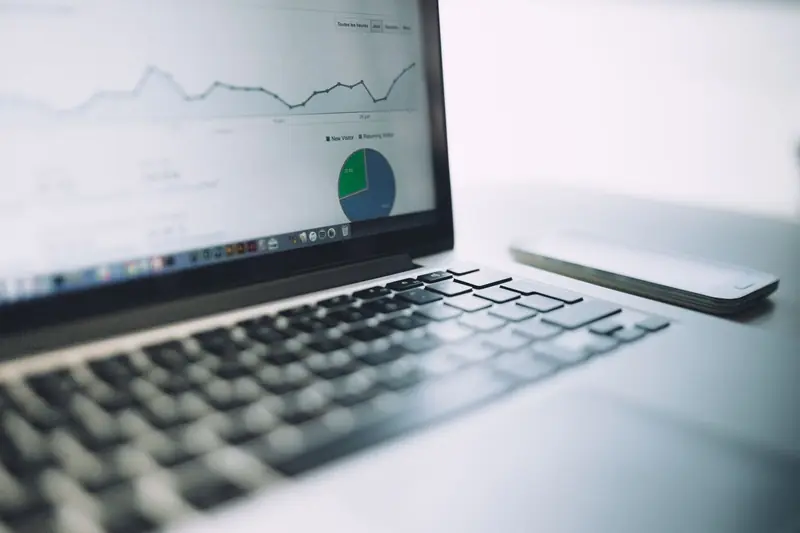 Laptop showing marketing charts on a desk