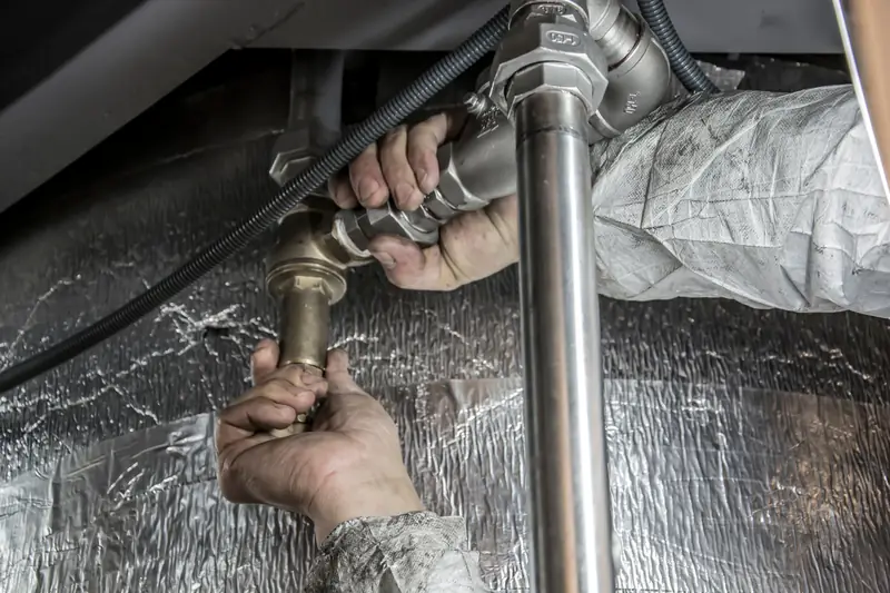 Plumber tightening a fitting on metal water pipes