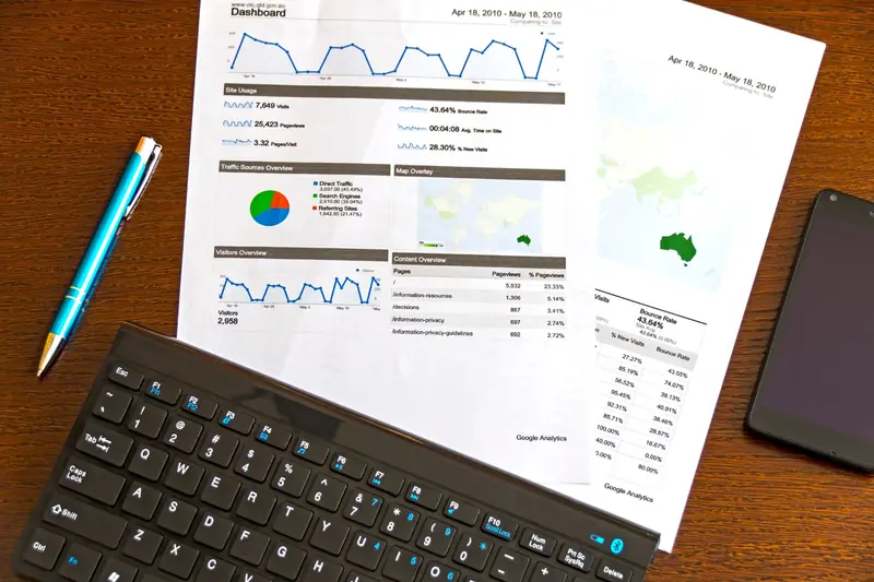 Desk with printed marketing report and laptop